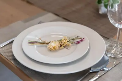 a white plate with a flower on it on a table at SUA HOTEL Hikifune in Tokyo