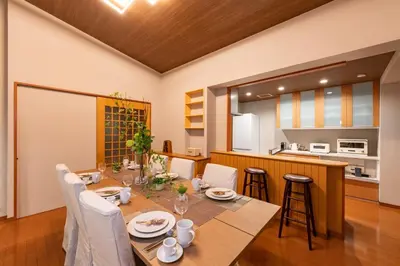 a dining room with a table and a kitchen at SUA HOTEL Hikifune in Tokyo