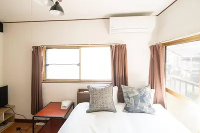 a bedroom with a bed and a window at Rea\u6771\u5411\u5cf64\u4e01\u76ee in Tokyo