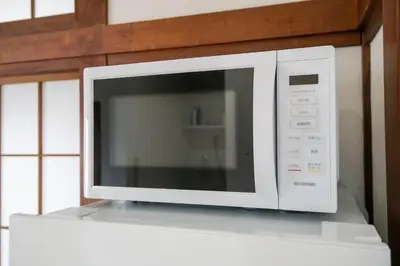 a microwave oven on top of a white shelf at Rea\u6771\u5411\u5cf64\u4e01\u76ee in Tokyo