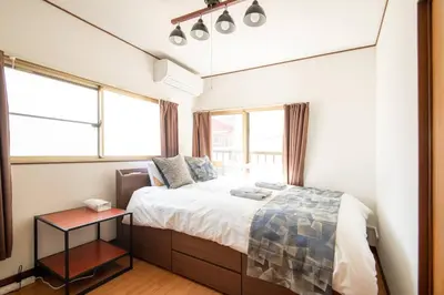 a bedroom with a bed and a table in it at Rea\u6771\u5411\u5cf64\u4e01\u76ee in Tokyo