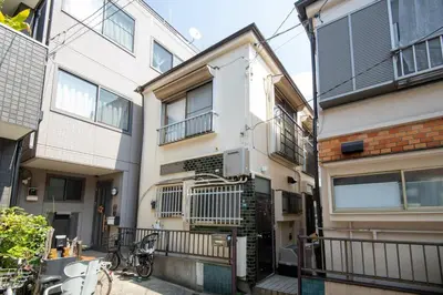 an apartment building with a bike parked in front of it at Rea\u6771\u5411\u5cf64\u4e01\u76ee in Tokyo