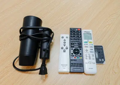 a black flashlight and remote controls on a table at LIVION V Hatagaya by Tranova in Tokyo