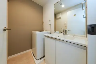 a bathroom with a toilet and a sink and a mirror at LIVION V Hatagaya by Tranova in Tokyo