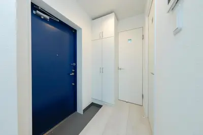 a blue door in a hallway with white cabinets at LIVION V Hatagaya by Tranova in Tokyo