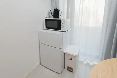 a microwave sitting on top of a white refrigerator at LIVION V Hatagaya by Tranova in Tokyo