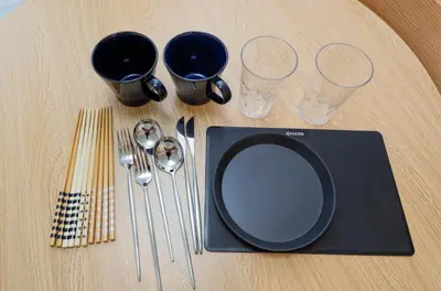 a table with a black plate and some wine glasses at LIVION V Hatagaya by Tranova in Tokyo