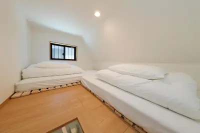 two beds in a white room with a window at Nakano Five by Tranova in Tokyo
