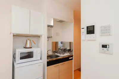 a kitchen with a white refrigerator and a microwave at Nakano Five by Tranova in Tokyo