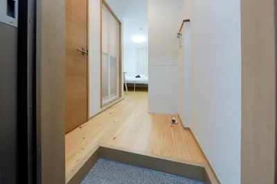 a room with a hallway with a door and a wooden floor at Nakano Five by Tranova in Tokyo