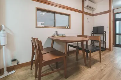 a dining room with a wooden table and chairs at Hidden Valley in Tokyo
