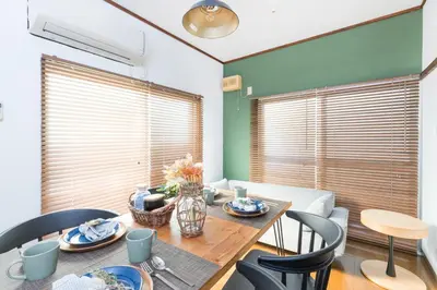 a dining room with a wooden table and chairs at Takamatsu Guest House in Tokyo