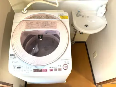 a washing machine and a sink in a bathroom at Takamatsu Guest House in Tokyo