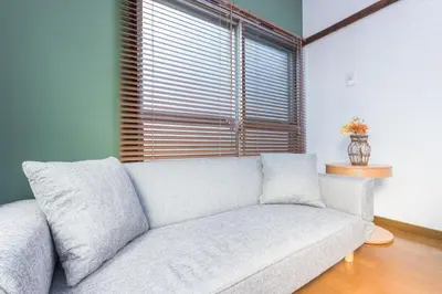 a white couch in a living room with a window at Takamatsu Guest House in Tokyo