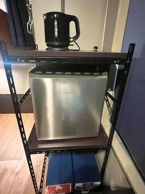 a microwave on a shelf with a coffee pot on top at Wasabi Mita Hotel in Tokyo
