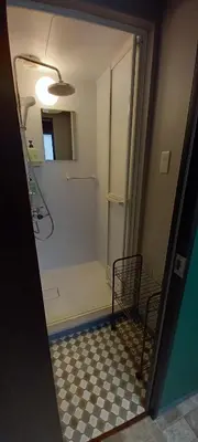 a bathroom with a shower with a checkerboard floor at Wasabi Mita Hotel in Tokyo