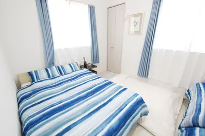 a bedroom with a bed with blue and white stripes at Aries Nishi-Shinjuku 302 in Tokyo