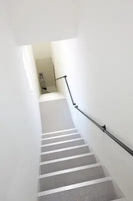 a stairway with white walls and white stairs at Aries Nishi-Shinjuku 302 in Tokyo