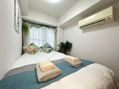 a bedroom with a bed with towels on it at nestay apartment tokyo itabashi in Tokyo
