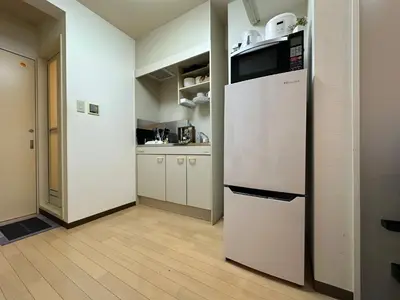 a kitchen with a white refrigerator in a room at nestay apartment tokyo itabashi in Tokyo