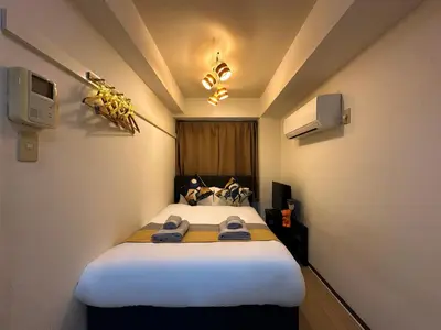 a small room with a bed with towels on it at nestay apartment tokyo itabashi in Tokyo