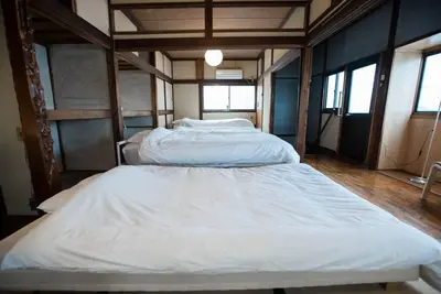 two white beds in a room with windows at 【70平米 長期予約大歓迎】6LDK/日本家屋貸切/大人数で寛げる空間 in Tokyo