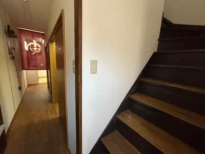 a hallway with stairs and a sign on the wall at Backpackers' asakusa share house 