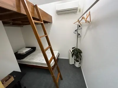 a small room with a bunk bed and a ladder at Backpackers' asakusa share house 