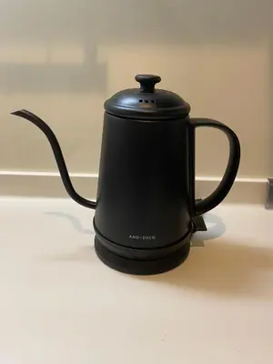 a black tea kettle sitting on a counter at EveryNet Shinjuku by Tranova in Tokyo
