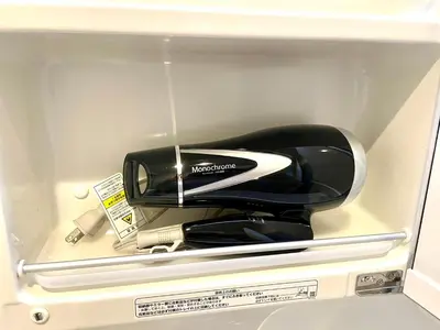 a hair dryer is sitting in a drawer at EveryNet Shinjuku by Tranova in Tokyo