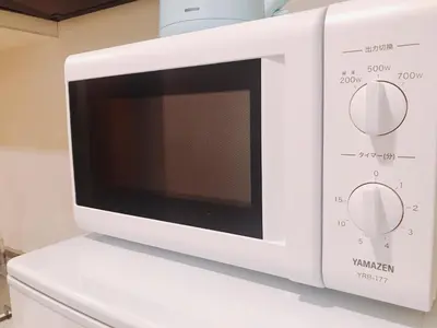 a white microwave oven sitting on top of a counter at tokyo sky dream shinjuku in Tokyo