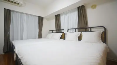 a bedroom with a white bed with white pillows at tokyo sky dream shinjuku in Tokyo