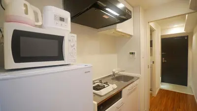 a kitchen with a microwave and a sink at tokyo sky dream shinjuku in Tokyo