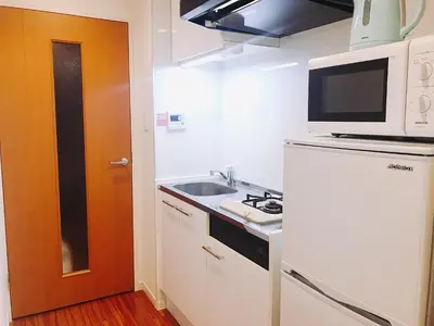 a small kitchen with a sink and a microwave at tokyo sky dream shinjuku in Tokyo