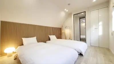 two beds in a hotel room with white sheets at Hotel STAY ARI Higashishinjuku in Tokyo