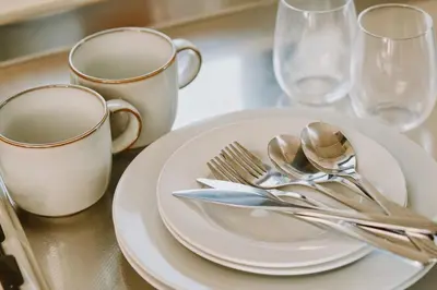 a table with white plates and silverware on it at Evergreen Apartment Hotel in Tokyo
