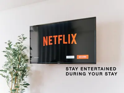 a television on a wall with a netflix sign at Evergreen Apartment Hotel in Tokyo