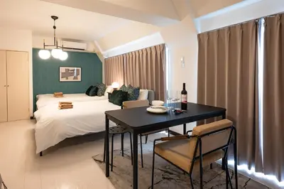 a bedroom with a bed and a table with a bottle of wine at \u30d7\u30ea\u30cd\u30c3\u30c4\u65b0\u5bbf\u30d3\u30eb4\u968e in Tokyo