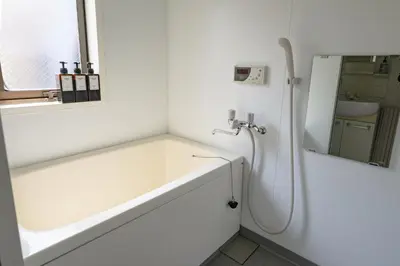 a white bathroom with a bath tub and a mirror at \u30d7\u30ea\u30cd\u30c3\u30c4\u65b0\u5bbf\u30d3\u30eb4\u968e in Tokyo