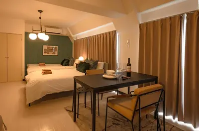 a bedroom with a bed and a table with a bottle of wine at \u30d7\u30ea\u30cd\u30c3\u30c4\u65b0\u5bbf\u30d3\u30eb4\u968e in Tokyo