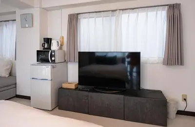 a living room with a large flat screen tv at \u30d7\u30ea\u30cd\u30c3\u30c4\u65b0\u5bbf\u30d3\u30eb4\u968e in Tokyo