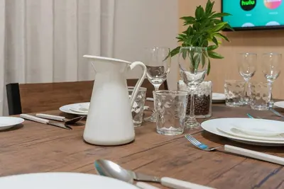 a wooden table with a white vase and plates and glasses at Oyama - Diamond Yu in Tokyo