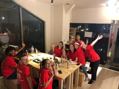 a group of people in red shirts sitting at a table at MAKOTO GUESTHOUSE -Limited Weight under 120kg, Age under 50years old- in Tokyo