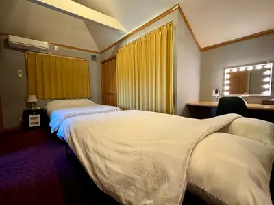 two beds in a hotel room with yellow curtains at Five room 120 SKY TREE SENSOJI FreeParking 1292sqft in Tokyo