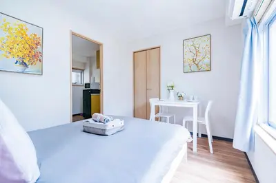 a white room with a bed and a table at 10min walk to Shinjuku EoS9 in Tokyo