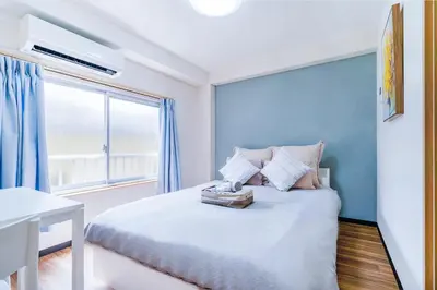 a bedroom with a bed with blue walls and a window at 10min walk to Shinjuku EoS9 in Tokyo