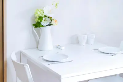 a white table with a vase with flowers on it at 10min walk to Shinjuku EoS9 in Tokyo