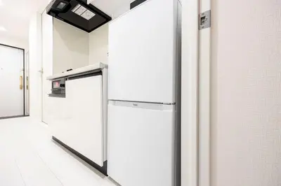 an empty room with a large white refrigerator at aLATO\u9326\u7cf8\u753a in Tokyo