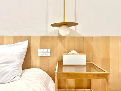 a bedroom with a bed and a night stand with a laptop at \u4e1c\u4eac\u4e0a\u91ce\u8d85\u7ea7\u4e2d\u5fc3 \u8bbe\u8ba1\u5e08\u623f\u95f4Yeoa \u4e0a\u91ce\u516c\u56ed3\u5206\u949f \u8f66\u7ad91\u5206\u949f \u8d85\u7ea7\u7e41\u534e \u514d\u8d39wifi \u6234\u68ee\u5439\u98ce in Tokyo