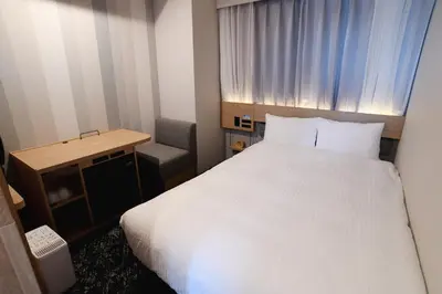 a hotel room with a white bed and a desk at Washington R&B Hotel Otsuka Eki Kitaguchi in Tokyo